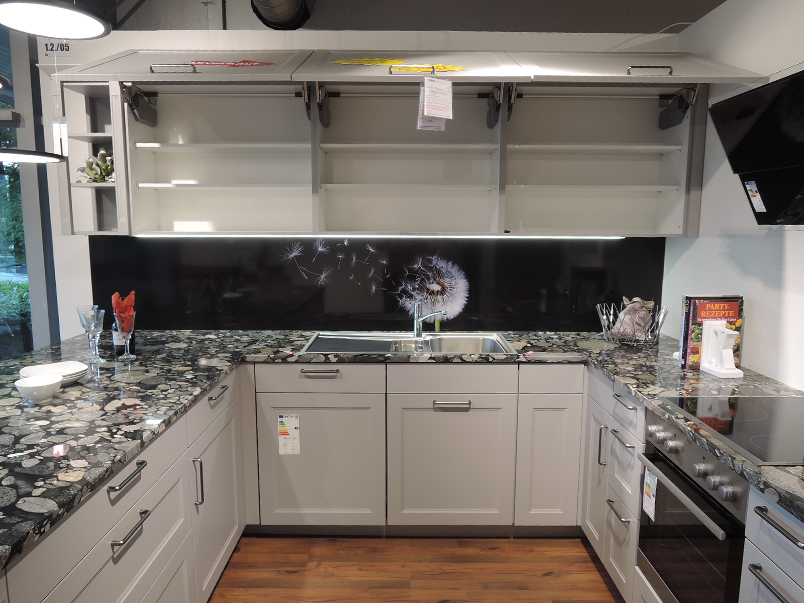 Blick in die geöffneten Hängeschränke über der Spüle