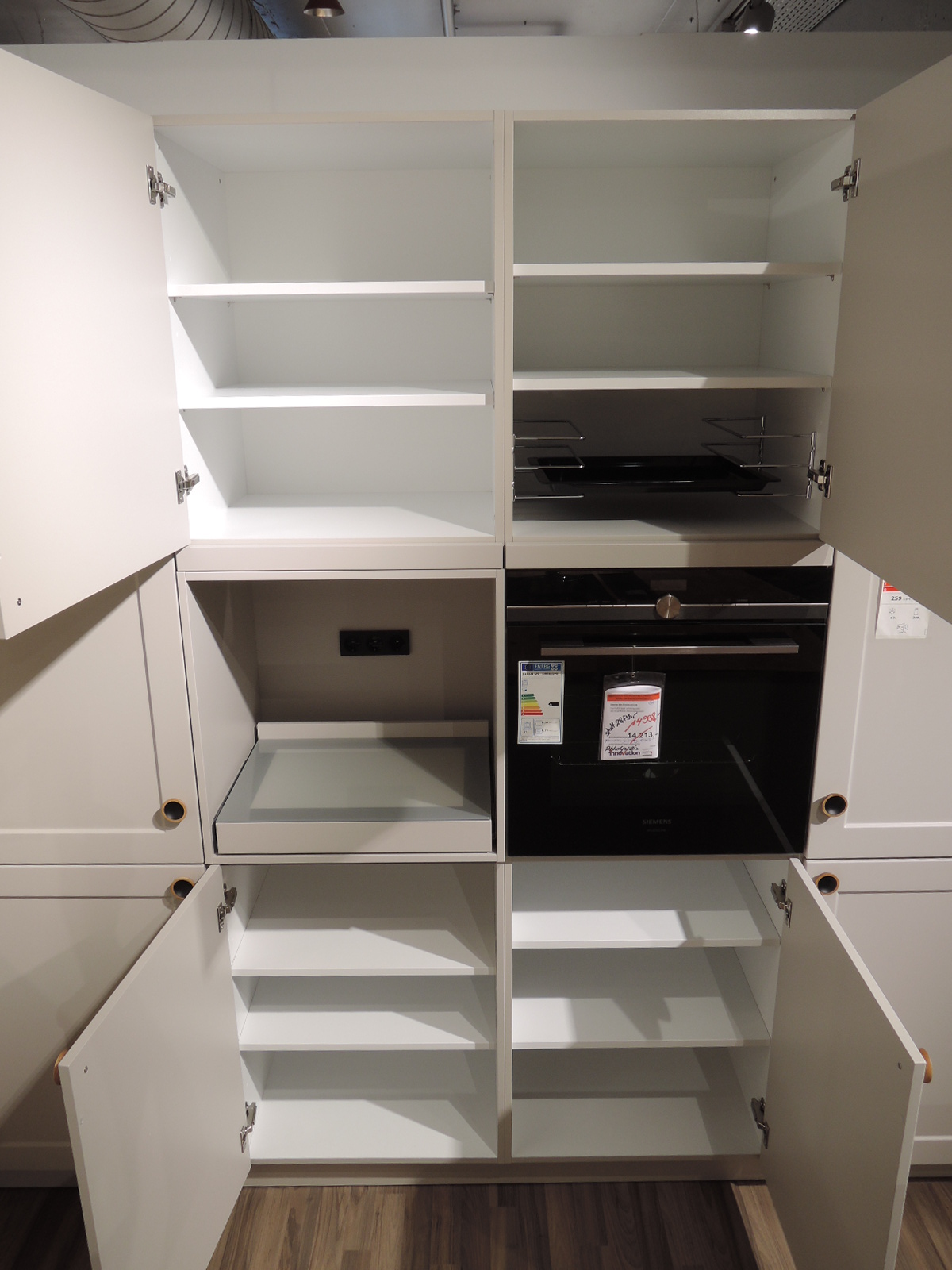 Blick in die geöffneten Schränke rechts vom Backofen und über und unter Backofen