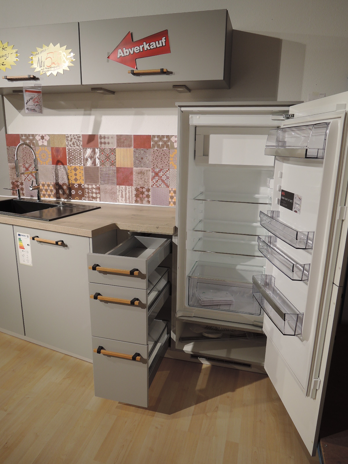 Blick in das geöffnete Kühlgerät sowie in die geöffneten Auszüge links vom Kühlgerät