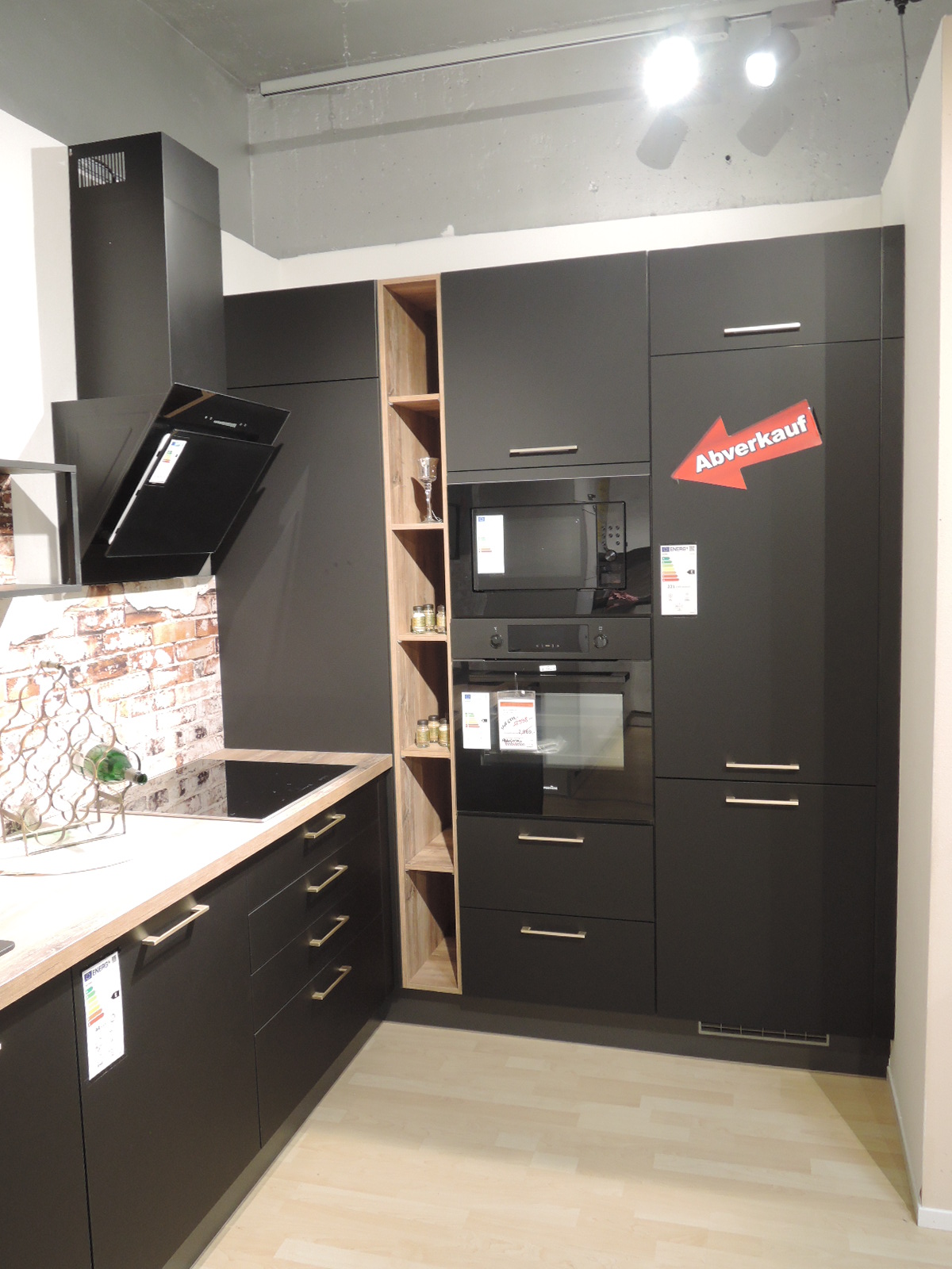 Blick auf die rechte Seite der Ausstellungsküche mit Blick auf den Backofen, die Einbau-Mikrowelle und das Kühlgerät