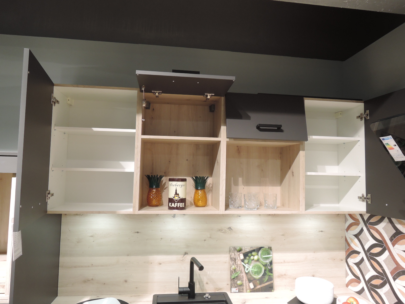 Blick auf die geöffneten Hängeschränke über der Spüle