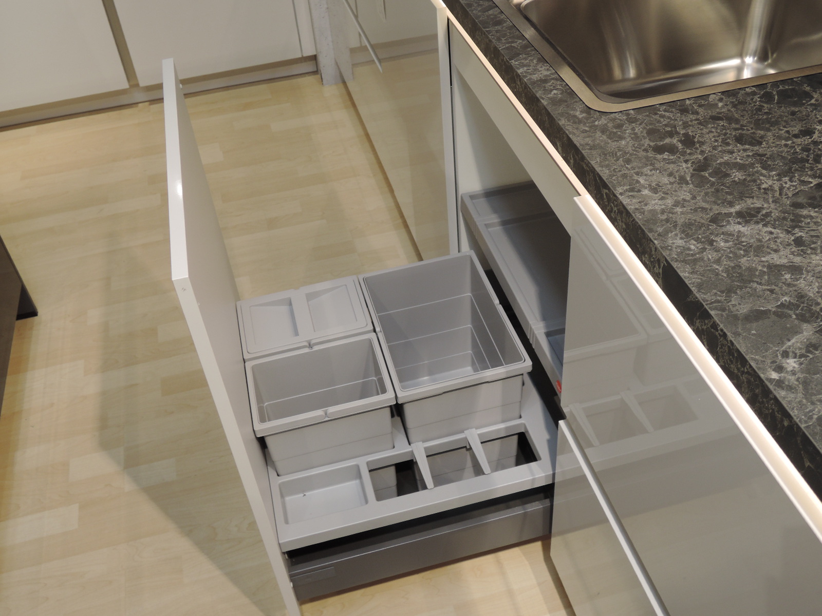 Blick in den geöffneten Spülenschrankauszug mit Mülltrennsystem