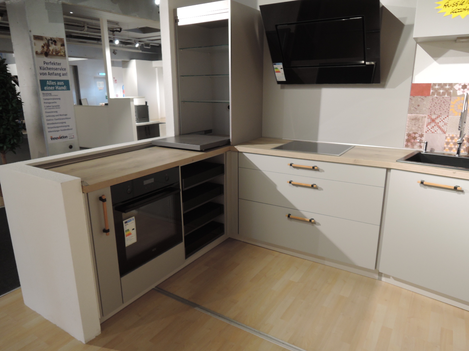 Blick in die Ecke der L-Küche mit geöffnetem Rolloschrank mit Auszugsplatte für z.B. Toaster