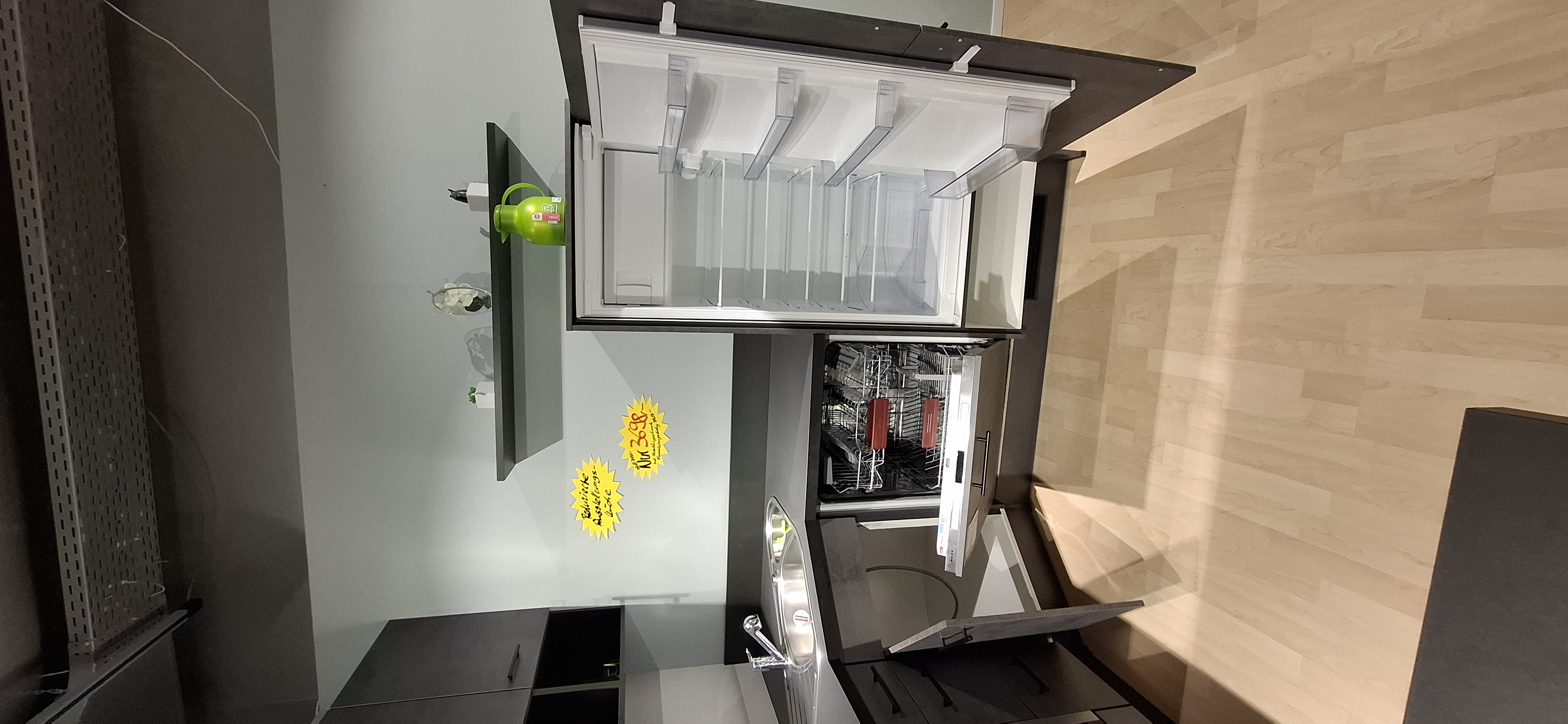 Blick in den geöffneten Spülenunterschrank, Geschirrspüler und Einbau-Kühlautomaten
