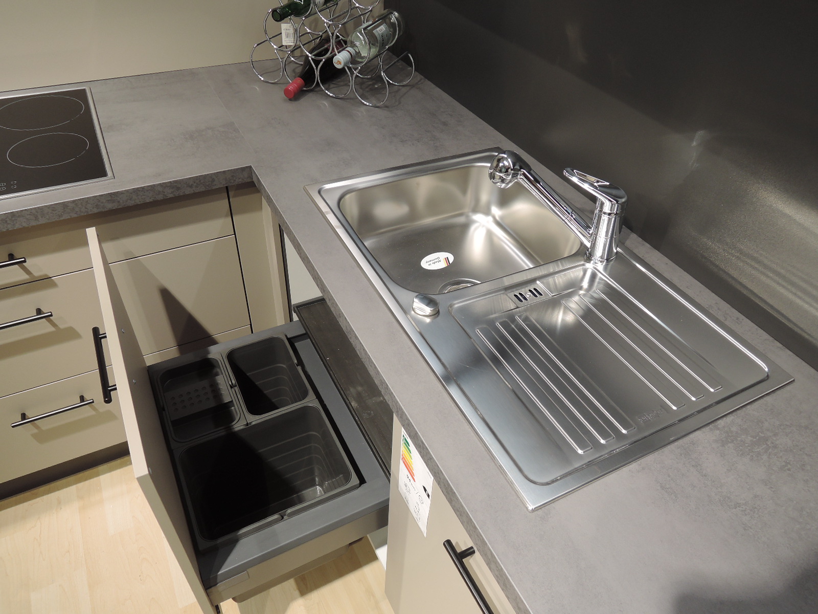 Blick auf die Einbauspüle und Armatur sowie in den geöffneten Müllauszug