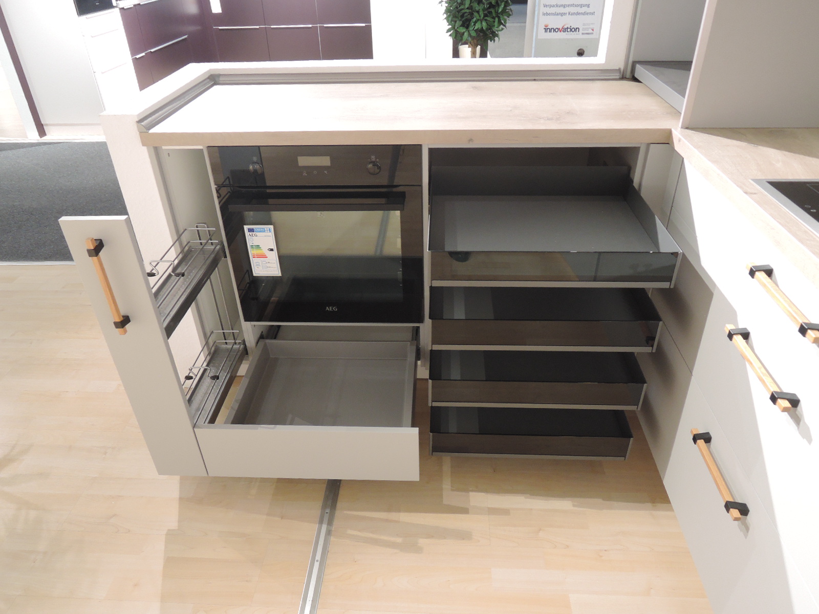 Blick in den Gewürzauszug links vom Herd und in die geöffneten Auszüge rechts vom Herd