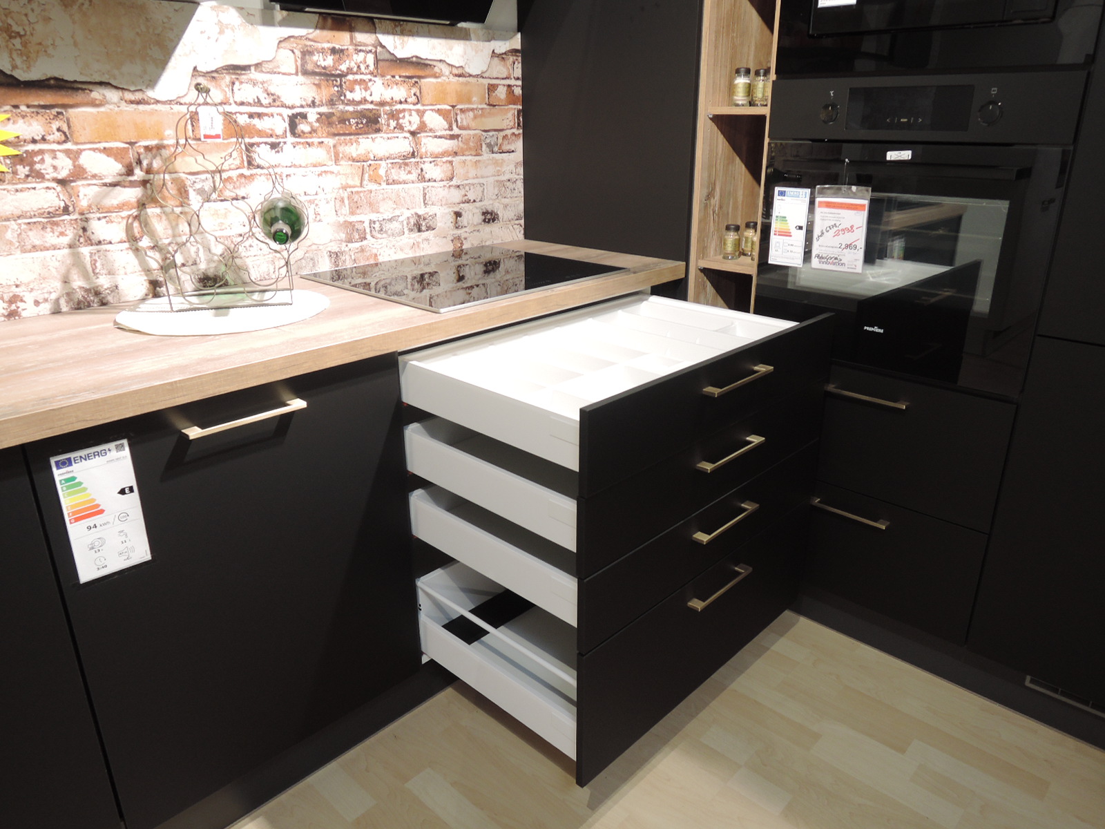 Blick auf die geöffneten Schublade und Auszüge unterhalb des Induktionskochfeldes